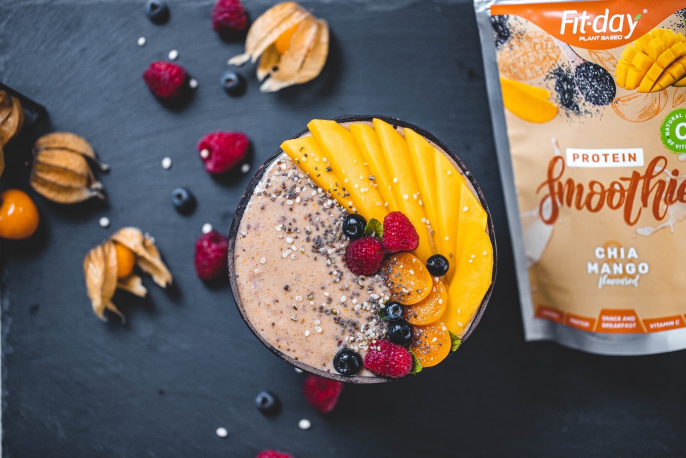 Smoothie bowl mango-berry s chia semínky, čerstvým mangem a malinami v kokosové misce